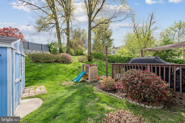 view of yard featuring an outdoor structure, a playground, and a storage unit