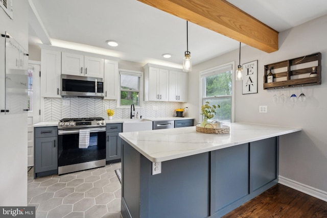 kitchen with a sink, decorative backsplash, stainless steel appliances, a peninsula, and light stone countertops