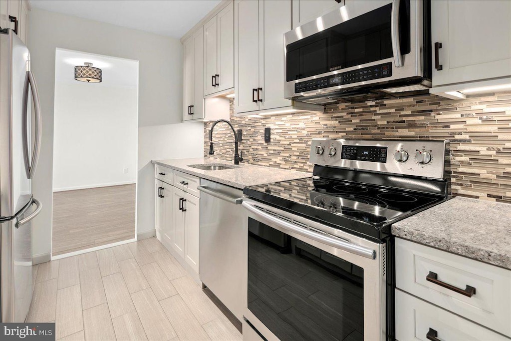 9701 Fields Rd Unit 1408, Gaithersburg, MD 20878 - kitchen with light stone counters, tasteful backsplash, white cabinetry, and stainless steel appliances