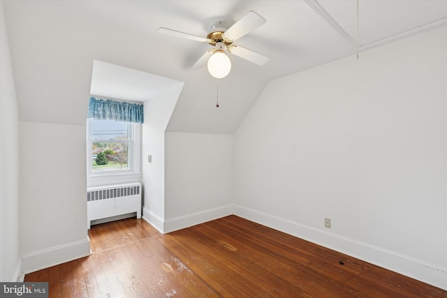 additional living space featuring attic access, baseboards, radiator heating unit, lofted ceiling, and hardwood / wood-style flooring