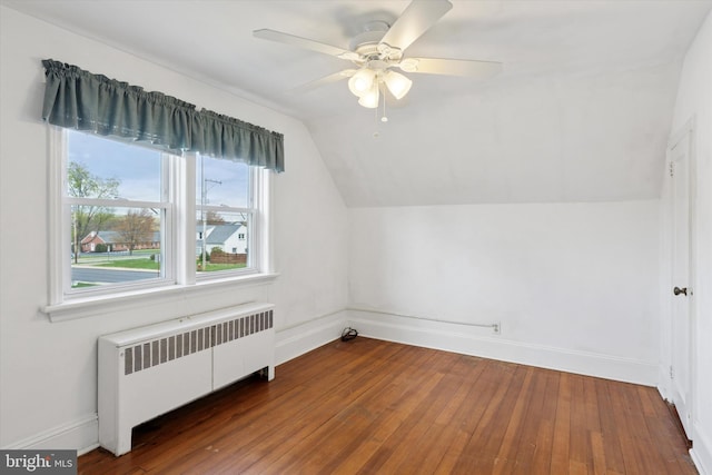 bonus room featuring radiator heating unit, hardwood / wood-style floors, lofted ceiling, and baseboards