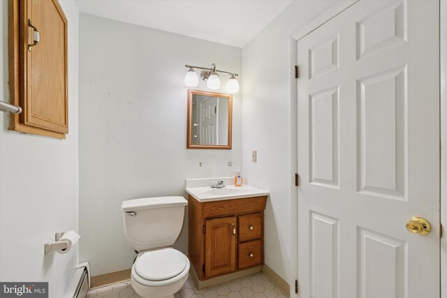 bathroom with tile patterned floors, vanity, a baseboard radiator, and toilet