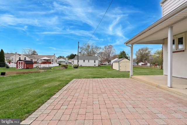 view of patio / terrace featuring a storage unit, an outdoor structure, and a residential view