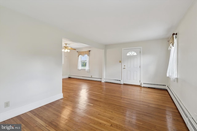 foyer entrance featuring a baseboard heating unit and hardwood / wood-style flooring