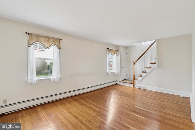 interior space featuring baseboards, light wood-style floors, stairway, and baseboard heating