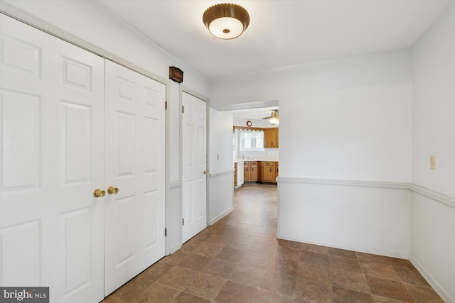 hallway featuring baseboards and stone finish floor