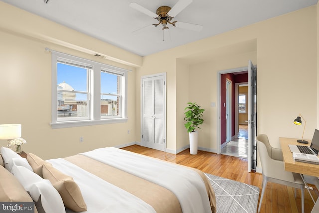 bedroom featuring baseboards, light wood-style floors, and a closet