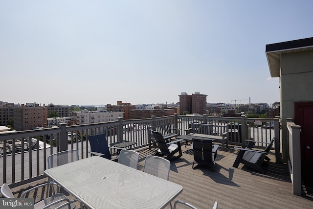 deck with outdoor dining space and a view of city