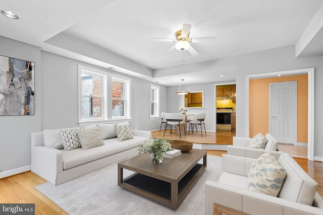 living room featuring recessed lighting, light wood-style floors, baseboards, and a ceiling fan