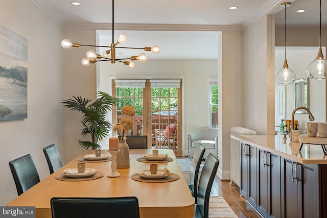 dining space with wood finished floors, crown molding, a chandelier, recessed lighting, and baseboards