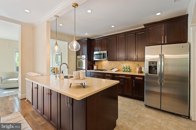 kitchen with appliances with stainless steel finishes, a sink, dark brown cabinets, crown molding, and recessed lighting