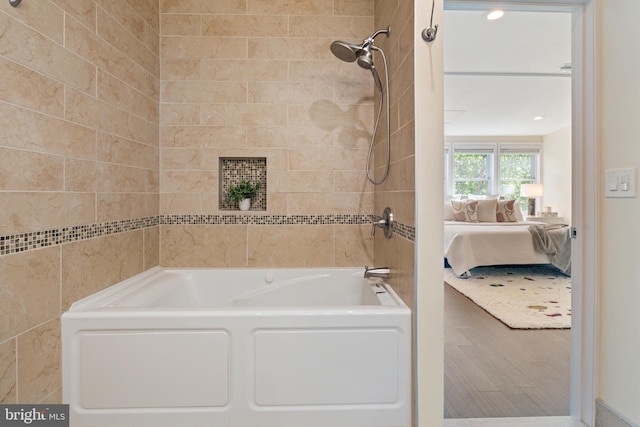 bathroom featuring ensuite bathroom, wood finished floors, and  shower combination