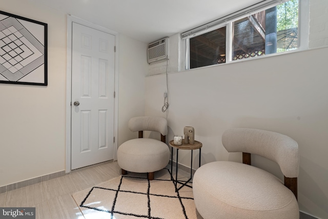living area with a wall unit AC and baseboards