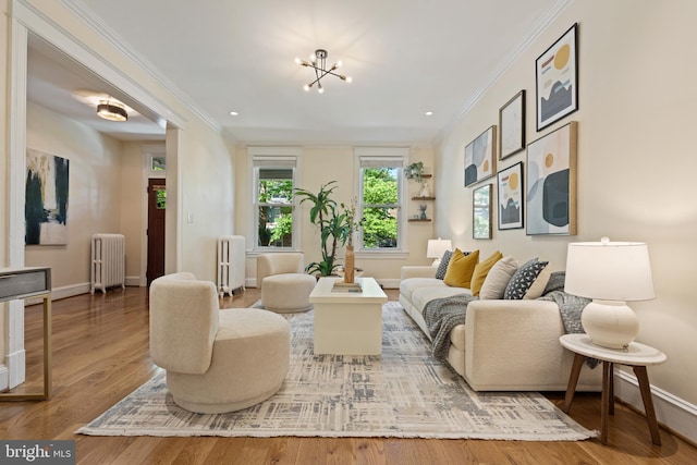 living area with radiator heating unit, ornamental molding, baseboards, wood finished floors, and recessed lighting