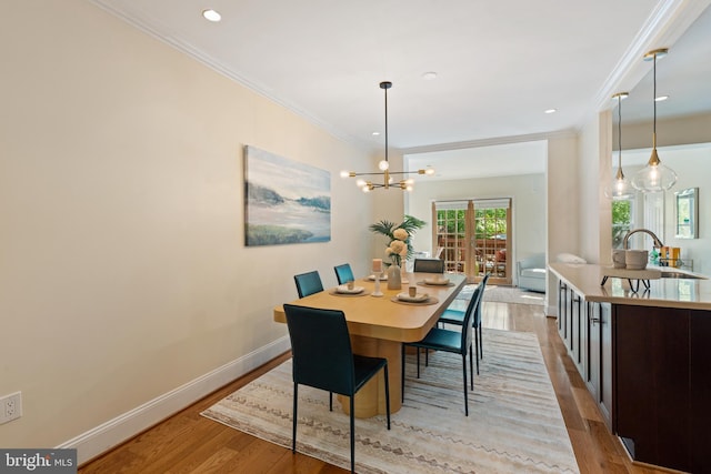 dining room featuring light wood finished floors, ornamental molding, baseboards, a chandelier, and recessed lighting