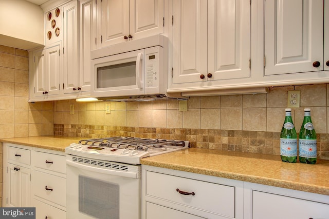 kitchen featuring light countertops, backsplash, white cabinets, and white appliances