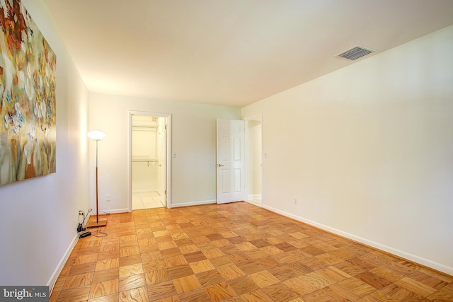 unfurnished room featuring baseboards and visible vents