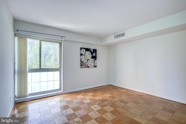 unfurnished room featuring baseboards and visible vents