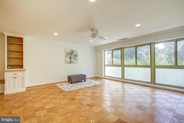 unfurnished room with crown molding, a ceiling fan, and baseboards