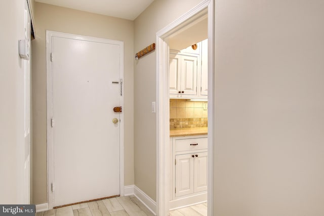 doorway to outside with baseboards and light wood finished floors