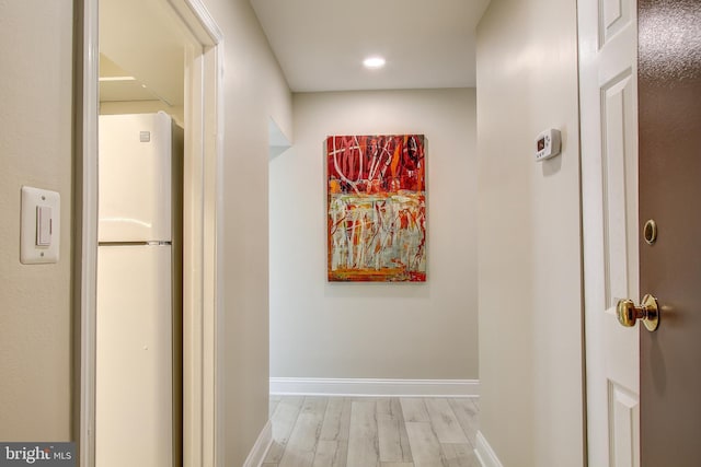 hallway featuring baseboards and light wood-type flooring