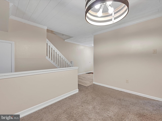 carpeted spare room featuring crown molding, baseboards, stairway, and a chandelier