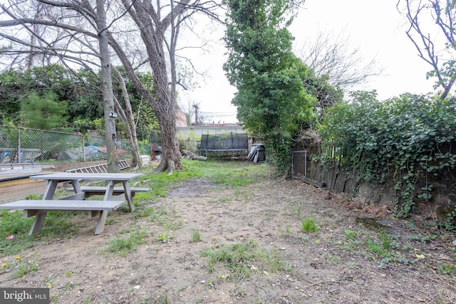 view of yard with a fenced backyard and a trampoline