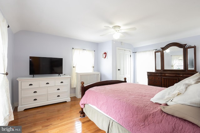 bedroom featuring lofted ceiling, a ceiling fan, and light wood-type flooring
