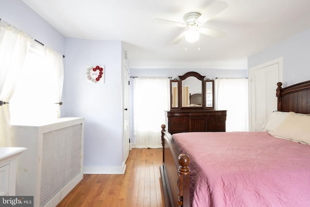 bedroom featuring ceiling fan, baseboards, and light wood-style floors