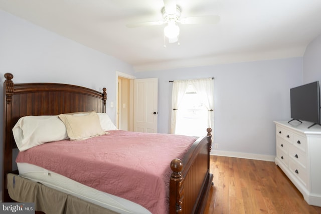 bedroom featuring ceiling fan, baseboards, and light wood-style flooring