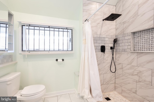 full bathroom featuring baseboards, toilet, marble finish floor, and tiled shower