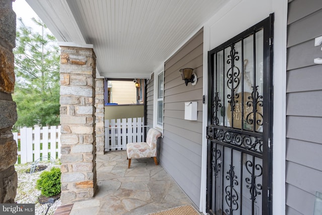 entrance to property with fence and covered porch