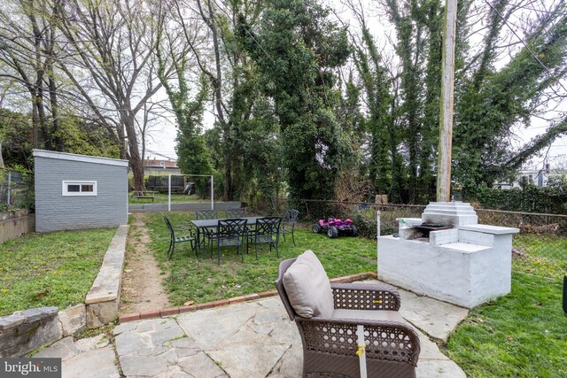 view of patio with a fenced backyard, an outbuilding, and outdoor dining area