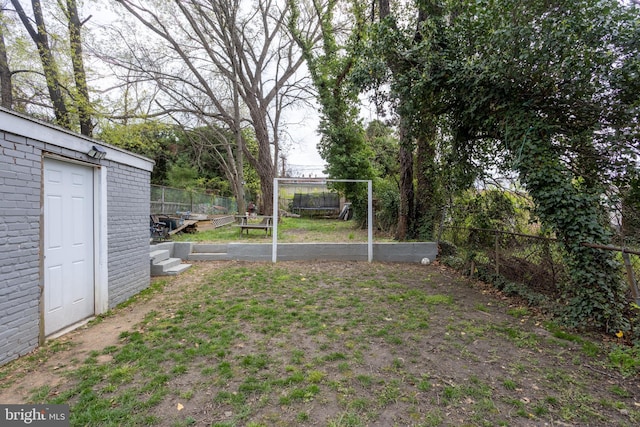 view of yard with fence and an outbuilding