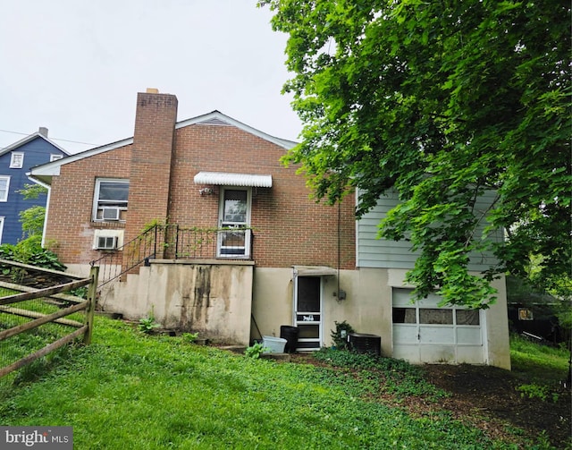 217 Main St, Delta, PA 17314 - rear view of house with a lawn, fence, a chimney, and brick siding