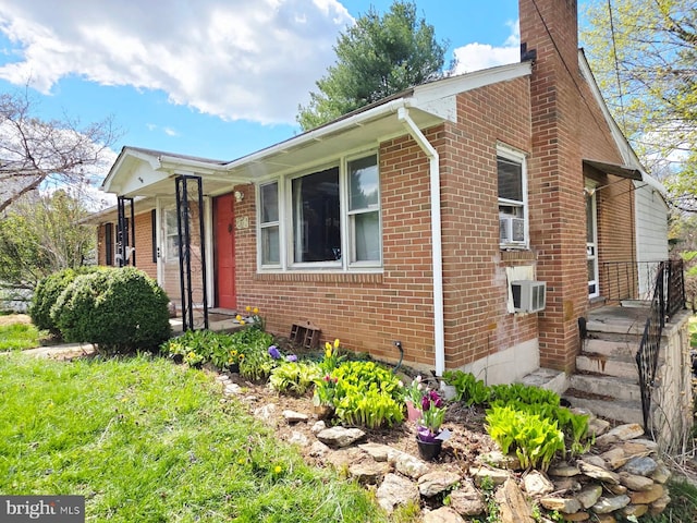 view of front of property with a chimney and brick siding