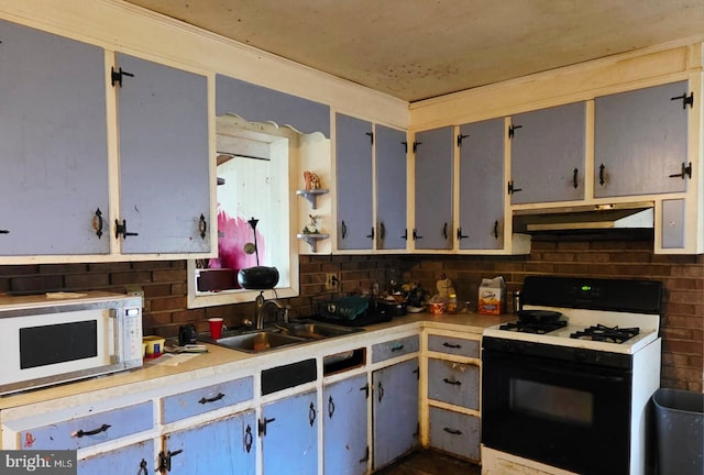 kitchen featuring white microwave, under cabinet range hood, a sink, range with gas stovetop, and decorative backsplash