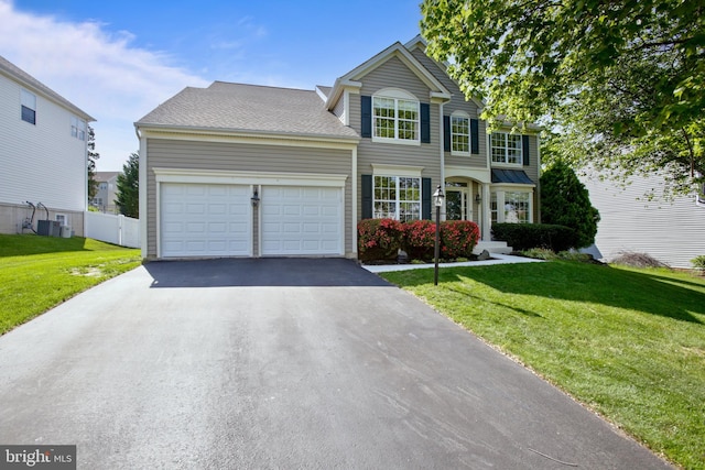 view of front of house featuring a garage, fence, a front yard, and aphalt driveway