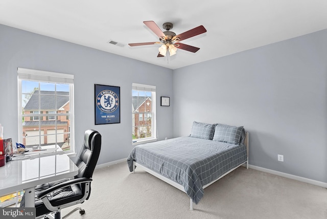 carpeted bedroom featuring baseboards, a ceiling fan, and visible vents
