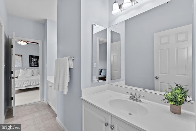 ensuite bathroom featuring vanity, a ceiling fan, baseboards, and ensuite bath