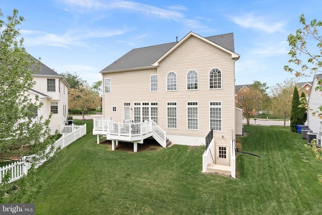 back of property with fence, roof with shingles, central AC, a deck, and a lawn