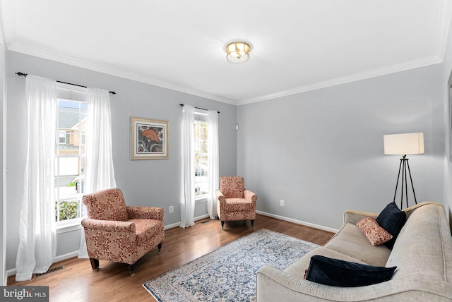 sitting room featuring crown molding, baseboards, a healthy amount of sunlight, and wood finished floors