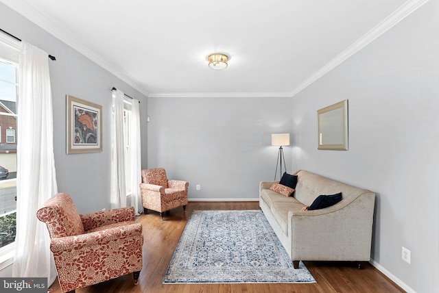 living area featuring crown molding, baseboards, and wood finished floors