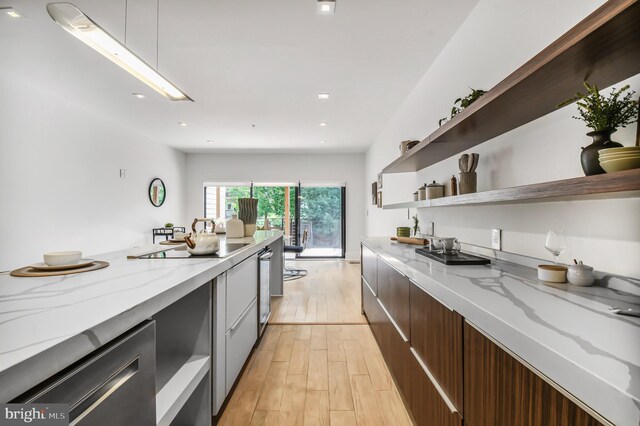 2515 Ontario Rd NW Unit 1, Washington, DC 20009 - kitchen featuring modern cabinets, open shelves, light wood-style flooring, light stone counters, and black electric cooktop