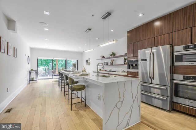 2515 Ontario Rd NW Unit 1, Washington, DC 20009 - kitchen with stainless steel appliances, a sink, open shelves, modern cabinets, and light wood-type flooring