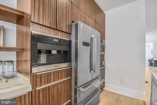 2515 Ontario Rd NW Unit 1, Washington, DC 20009 - kitchen featuring appliances with stainless steel finishes, light wood finished floors, and baseboards