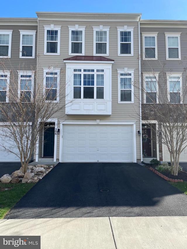 view of property with a garage and aphalt driveway