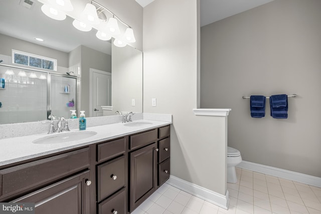 bathroom featuring a sink, a stall shower, toilet, and double vanity