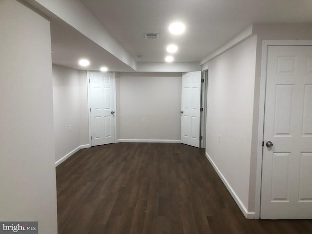 finished basement featuring baseboards, visible vents, and dark wood-style floors