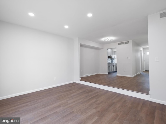 unfurnished living room featuring baseboards, visible vents, recessed lighting, and dark wood-type flooring